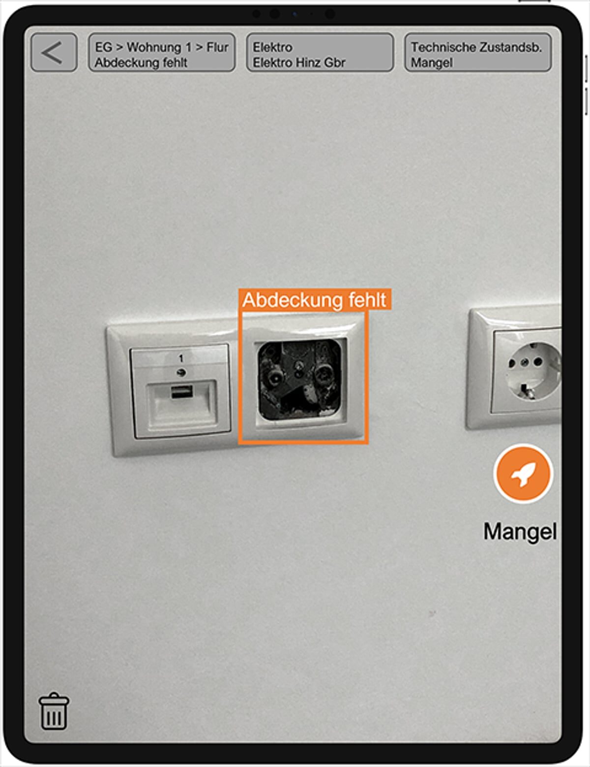 Tablet mit Foto einer Wanddose, die KI meldet: Abdeckung fehlt